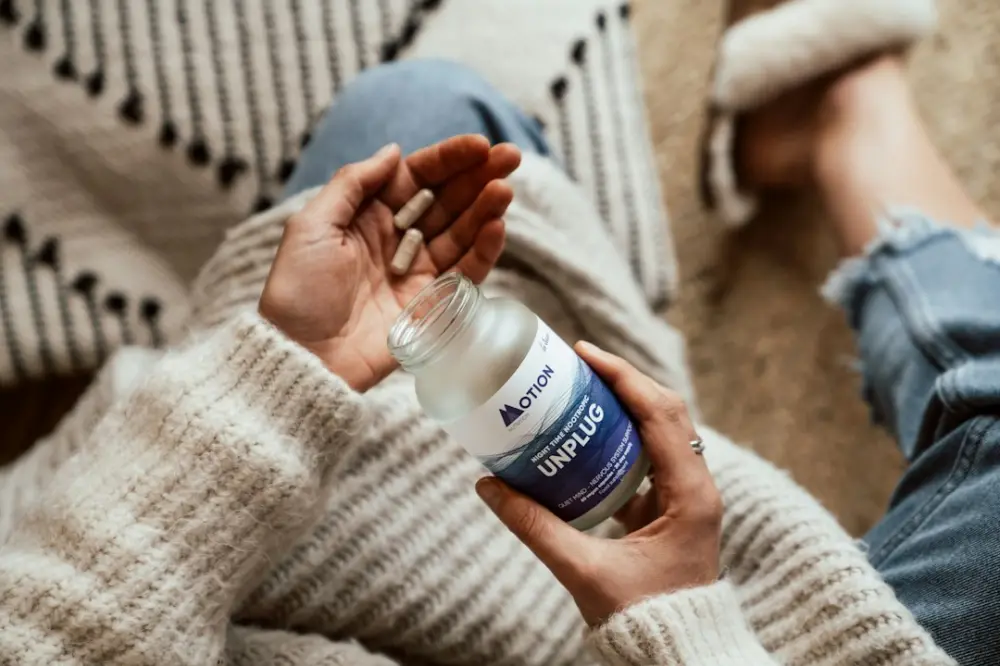 Person holding blue and white labeled plastic bottle, illustrating assessing uncertainty in supplement information